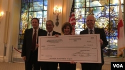 台灣捐贈美國紅十字會的50萬美元支票，左起為美國國務院台灣協調處處長何樂進、台灣駐美代表高碩泰、美國紅十字會會長麥戈文女士、美國在台協會執行理事羅瑞智(2017年9月12日，美國之音鍾辰芳拍攝)