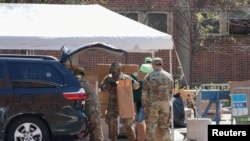 疫情期間，美國陸軍國民警衛隊員在紐約市曼哈頓哈萊姆區向民眾分發由多家市政府機構提供的免費食物。(2020年4月15日)