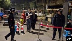 新疆喀什居民走过一个露天市场的安全检查站。 （2017年11月4日）