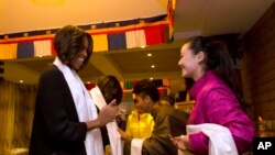 美国第一夫人米歇尔•奥巴马带着两个女儿和母亲来到成都一家西藏餐馆用午餐，受到藏族学生的欢迎。（2014年3月26日）