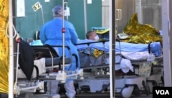 寒冷天气下医护人员为在明爱医院急症室外等候入院的病人盖保暖毡 (美国之音/汤惠芸)