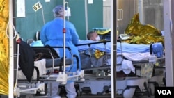 寒冷天氣下醫護人員為在明愛醫院急症室外等候入院的病人蓋保暖氈。（美國之音湯惠芸）