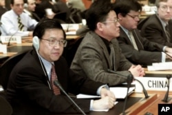 2001年12月19日星期三，中國首席貿易談判代表龍永圖（最左邊）出席在瑞士日內瓦舉行的世界貿易組織總理事會會議。中國作為世界貿易組織的新成員首次參加了這次會議。