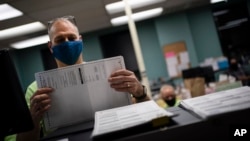 威斯康星州的選舉工作人員在選舉日整理提前投票和郵寄選票（美聯社2020年11月3日）