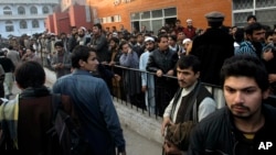 人们聚集在救治塔利班袭击中受伤学生们的医院前