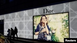 北京市民走過一家商場外的迪奧廣告牌。（2016年11月30日）