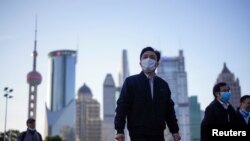 戴著口罩的行人行走在上海陸家嘴金融區的街道上。（2020年3月19日）