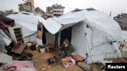 2025年2月6日，以色列和哈馬斯之間的停火期間，一名巴勒斯坦男子在下雨天坐在加沙的帳篷外。