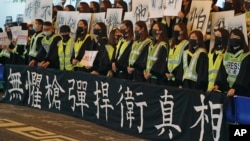 香港中文大學畢業生在2019年11月7日的畢業典禮上戴口罩手舉標語橫幅抗議。