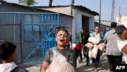 2023年10月28日，在代爾巴拉赫，巴勒斯坦人湧入聯合國運營的一個援助供應中心，該中心向流離失所的家庭分發食品，此前以色列呼籲加沙北部100多萬居民向南遷移，以確保安全.(法新社)