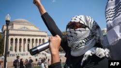 Пропалестинские демонстранты маршируют по кампусу Колумбийского университета, чтобы отметить первую годовщину войны между ХАМАС и Израилем в Нью-Йорке 7 октября 2024 года