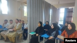 在重新開放的阿富汗大學教室裡，男生和女生被用布簾隔開。