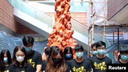 资料照：香港大学学生在校园内的国殇柱前为八九六四死难者默哀。（2020年6月4日）