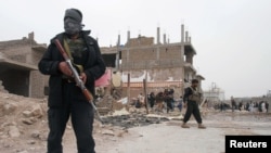 阿富汗警察3月13日在赫拉特省的汽车炸弹攻击现场。