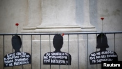 這些懸掛在智利總統府外欄杆上的黑色紙板剪影像代表著2015年智利的聖地亞哥一場抗議集會中在前智利獨裁總統奧古斯托·皮諾切特（Augusto Pinochet）執政期間遭受人權迫害的受害者們。