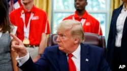 特朗普总统在白宫椭圆形办公室会晤2019年美国特殊奥林匹克运动队成员并接受媒体拍照时讲话。(2018年7月18日)