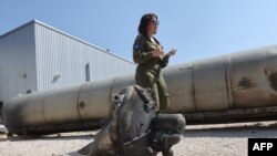 ທະຫານອິສຣາແອລຄົນນຶ່ງ ຢືນຢູ່ຂ້າງໆລູກສອນໄຟຂີປະນາວຸດຂອງອີຣ່ານ ທີ່ຕົກຢູ່ໃນອິສຣາແອລ ໃນທ້າຍອາທິດທີ່ຜ່ານມາ, ໃນລະຫວ່າງການຢ້ຽມຢາມຂອງສື່ມວນຊົນ ຢູ່ທີ່ຖານທັບທະຫານ ຈູລີສ (Julis) ໃກ້ກັບເມືອງ ເຄີຢັດ ມາລາຊີ (Kiryat Malachi) ທາງພາກໃຕ້ຂອງອິສຣາແອລ ໃນວັນທີ 16 ເມສາ 2024.