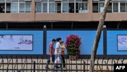 2020 年9 月28 日，戴著口罩的行人從仍然關閉的武漢華南海鮮批發市場旁走過。（法新社)