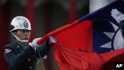 一名台灣士兵在台北中正紀念堂前降下台灣國旗。 （資料照片）