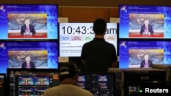 馬來西亞吉隆坡的APEC視頻會議中心的工作人員在觀看中國領導人習近平發表視頻講話。 （2020年11月19日）