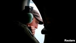 一架在印度洋南部上空搜索失踪马航班机残骸的澳大利亚皇家空军AP-3C猎户座飞机上的机组人员透过机窗查看海面。（2014年3月26日）