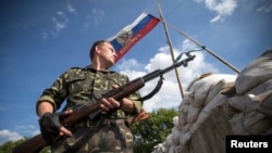 2014年6月24日一名親俄分離分子在東烏盧甘茨克地區的里斯坦斯克鎮外路上的檢查哨警戒