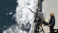 2023年5月19日星期五，一名美國海軍水手在霍爾木茲海峽的保羅·漢密爾頓號航空母艦上的機槍旁站崗。(美聯社圖片)