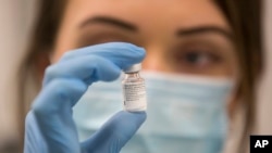 英國一名醫務人員手拿一瓶輝瑞-BioNTech新冠病毒疫苗。