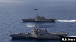 美軍“蒙哥馬利”號（USS Montgomery）（上）和“吉福茲”號（USS Gabrielle Giffords）瀕海戰鬥艦2020年1月20日在一架海鷹直升機的掩護下在南中國海執行任務。