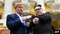 兩名長相扮相很像金正恩和特朗普的男子2019年2月22日在越南河內歌劇院前面的階梯上舉行“模擬峰會”。