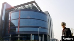 中芯國際在上海開業時一名保安站在樓前。（2001年11月22日）