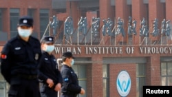 當世衛組織新冠病毒源頭調查組視察武漢病毒研究所期間，中國保安人員在研究所外站崗。（路透社2021年2月3日）