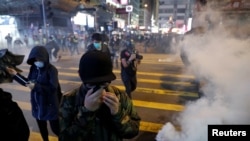 香港聖誕節平安夜舉行的抗議活動中反政府示威者逃離警察發射的催淚彈。 （2019年12月24日）