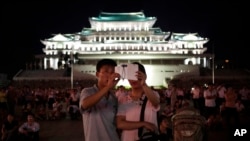 北韓一對夫婦在首都平壤金日成廣場利用智能手機拍攝煙花表現。（資料圖片）