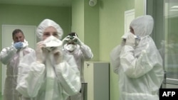 意大利紅十字會工作人員穿好防護衣準備在羅馬的菲烏米奇諾機場防疫檢測從中國武漢飛抵的旅客。（2020年1月23日）