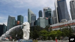 在新加坡濱海灣地區，大衆在魚尾獅雕像前拍照留念，與金融天際線相映成趣。 (資料照片，2020年6月30日）