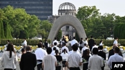 ບັນ​ດາ​ຜູ້​ແທນ​ວາງດອກ​ໄມ້​ຢູ່​ພິ​ທີ​ໄວ້​ອາ​ໄລ​ສັນ​ຕິ​ພາບ ຢູ່ສວນ​ອະ​ນຸ​ສອນ​ສະ​ຖານ​ສັນ​ຕິ​ພາບ ໃນ​ນະ​ຄອ​ນ ຮິ​ໂຣ​ຊິ​ມະ, 6 ສິງ​ຫາ 2024. (Photo by JAPAN POOL / JIJI PRESS / AFP) / J