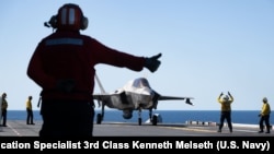 2025年7月14日，在“护身军刀25”演习期间，一架美国海军陆战队的F-35B闪电II飞机准备从两栖攻击舰“美国号”的飞行甲板上起飞，同时在珊瑚海进行飞行作业。