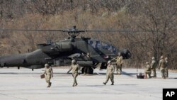 ​ທະ​ຫານ ສະ​ຫະ​ລັດ ກຽມ​ພ້ອມ​ເພື່ອ​ທຳ​ການ​ຊ້ອມ​ຍິງ​ລູກ​ປືນ​ແທ້​ໃກ້​ກັບ​ເຮືອ​ບິນ ເຮ​ລິ​ຄັອບ​ເຕີ ອາ​ປາ​ເຊ ໃນ​ລະ​ຫວ່າງ​ການ​ຊ້ອມ​ລົບ​ກັບ ເກົາຫຼີ​ໃຕ້, ເມືອງ ໂປ​ຊອນ, ເກົາຫຼີ​ໃຕ້, 14 ພະ​ຈິກ, 2023.(AP Photo/Lee Jin-man)