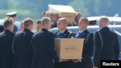 馬航MH17班機部份遇難者的遺體靈柩7月23日抵達荷蘭埃因霍恩機場。機場上舉行了接機儀式。遇難者的靈柩正在被從抬下飛機，安放在靈柩車裡。
