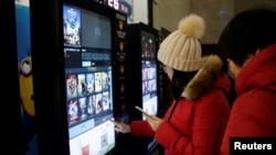 大眾在天津一家影院自動售票機前印電影票 (資料圖片)