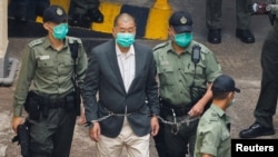 香港壹傳媒創辦人黎智英戴著手銬從警車走向法庭。 （2020年12月12日）