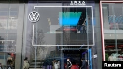 ແຟ້ມພາບ - ພວກຄົນຍ່າງຜ່ານ Store X ທີ່ເປັນຮ້ານວາງສະແດງລົດຍົນ ໂວກສແວເກັນ ໃນເມືອງ ເສິງດູ ຂອງແຂວງຊີສວນ, ປະເທດຈີນ, ວັນທີ 10 ມັງກອນ 2021.