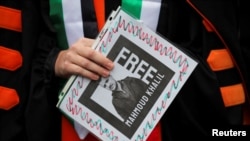 Участник акции протеста в Лос-Анджелесе держит плакат с фотографией Махмуда Халила, 11 марта 2025 года