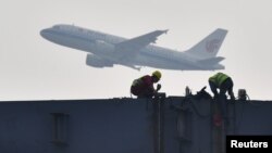 四川成都展覽中心建築工地上空飛過的中國國航飛機。（2020年2月26日）