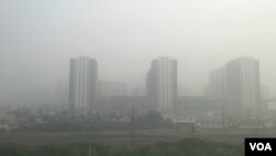 2016年10月14日，北京與河北廊坊交界處霧霾中的樓群。（美國之音葉兵拍攝）
