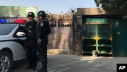 在新疆库尔勒市，警察站在一个被认为用于再教育的中心附近。（2017年11月2日）