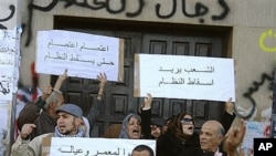 利比亞抗議者高舉標語牌。左上方的標語﹕“罷工﹐直到這個政權垮臺為止。