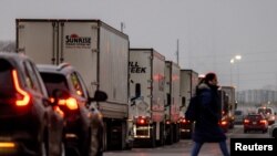 2025 年 2 月 3 日，運輸貨車沿著通往美加邊境大使橋的休倫教堂路行駛。（路透社照片）