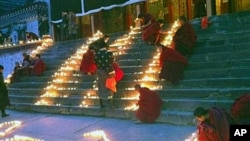 中國四川阿壩藏族羌族自治州的僧侶1月23日在一所寺廟點燃蜡燭為藏人祈福